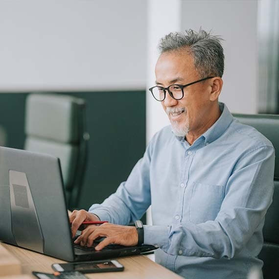 man in glasses on computer