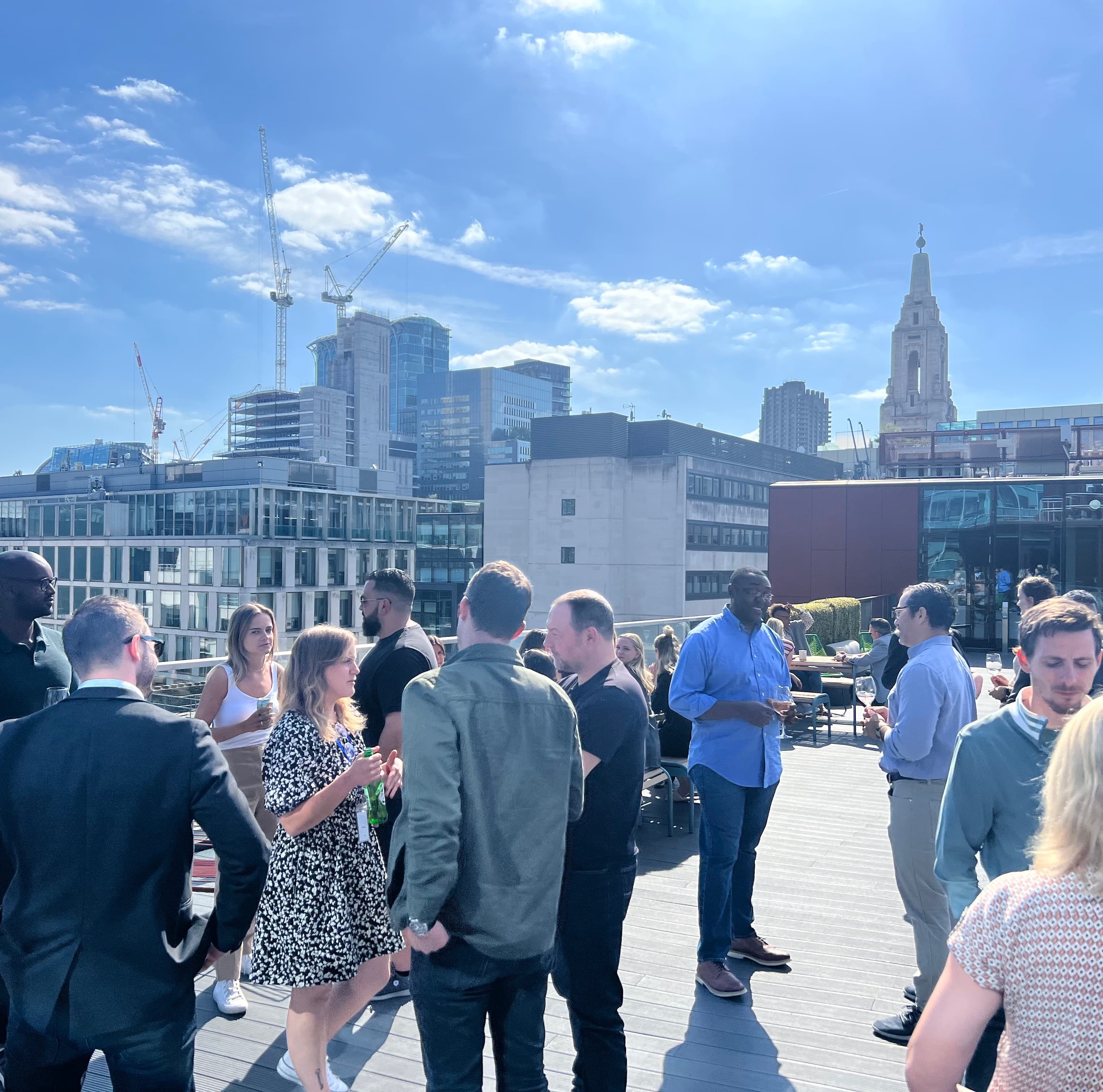 coworkers having happy hour on a deck overlooking the city